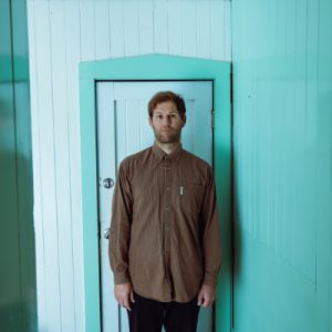 Timothy Blackman standing infront of a door.